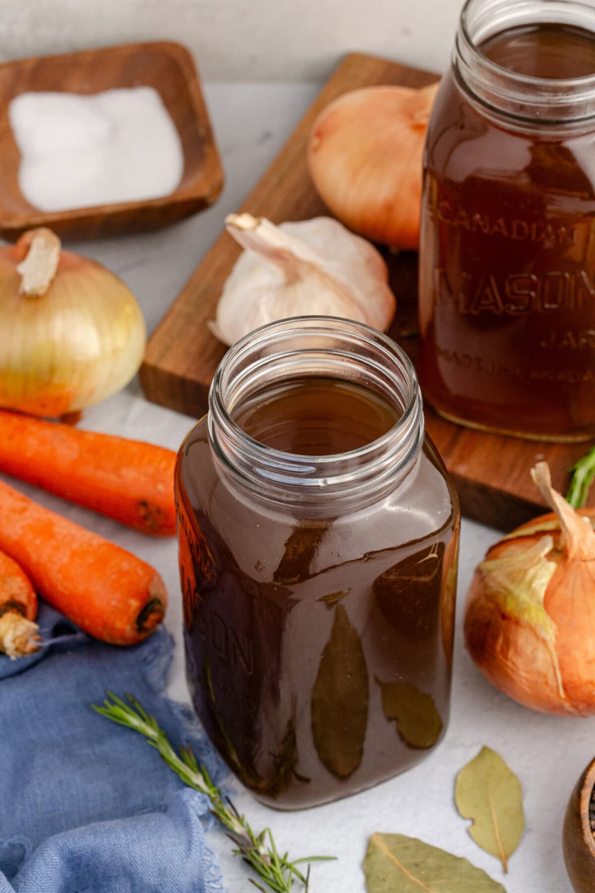 Jar of Vegetable Broth with vegetables in the background