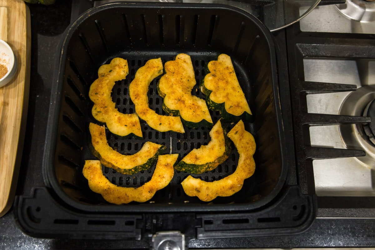 acorn squash slices in an air fryer basket