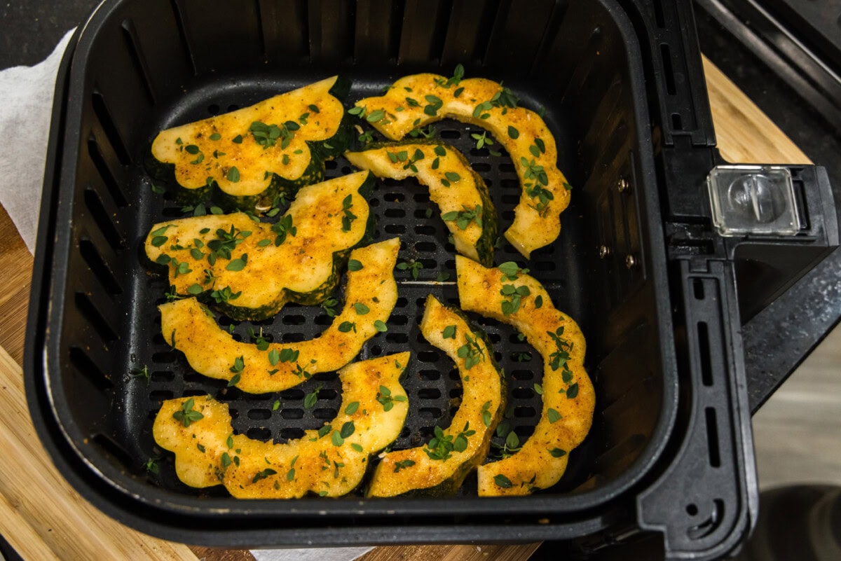 fresh thyme on top of roasted acorn squash slices