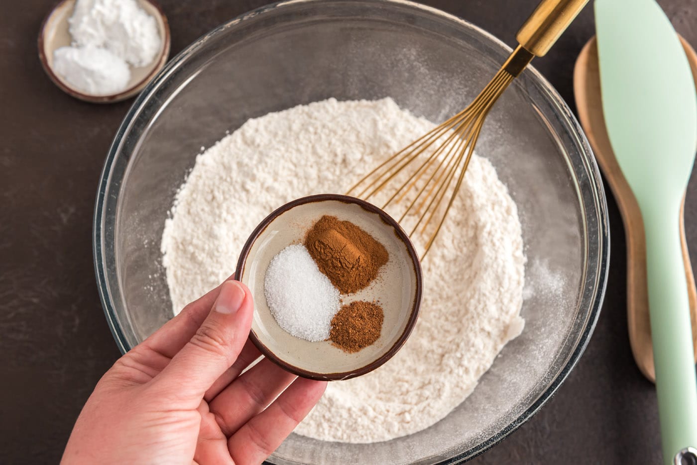 adding spices to flour in a bowl