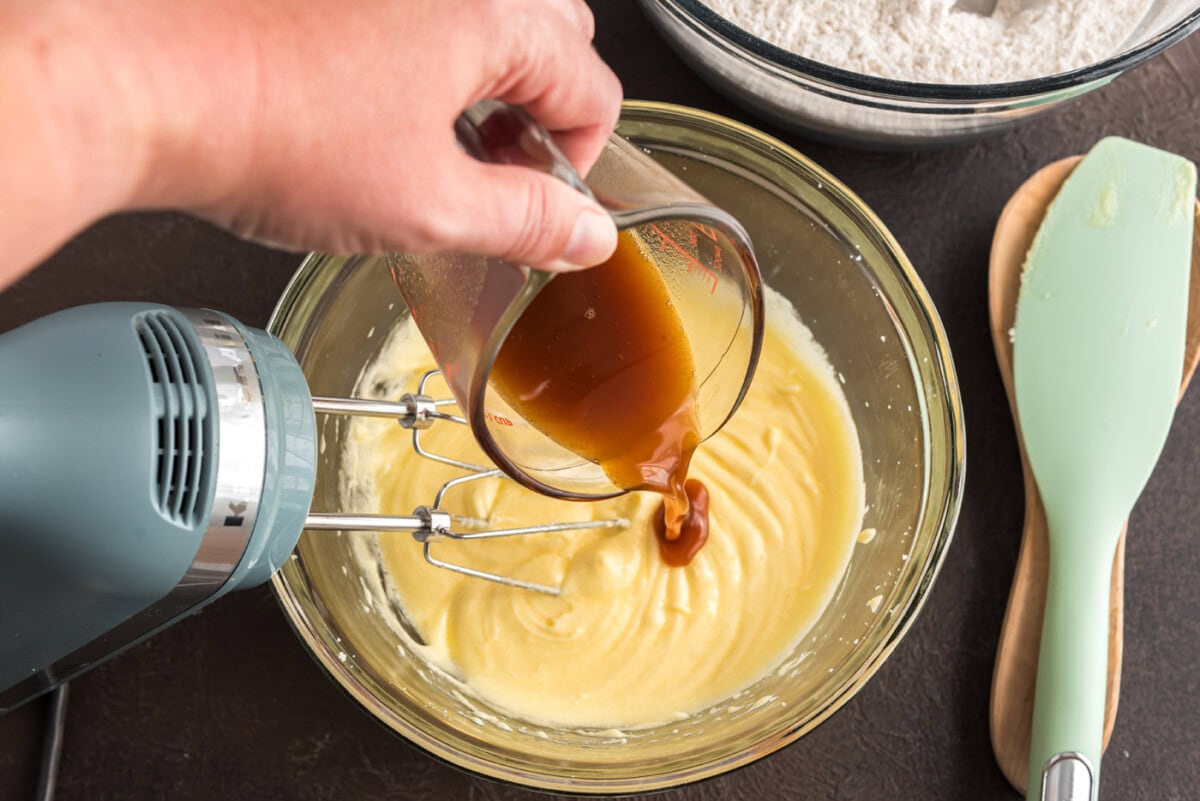 pouring apple cider into doughnut batter
