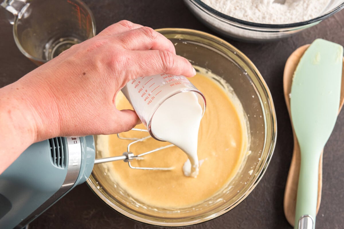 pouring buttermilk into apple cider donut batter