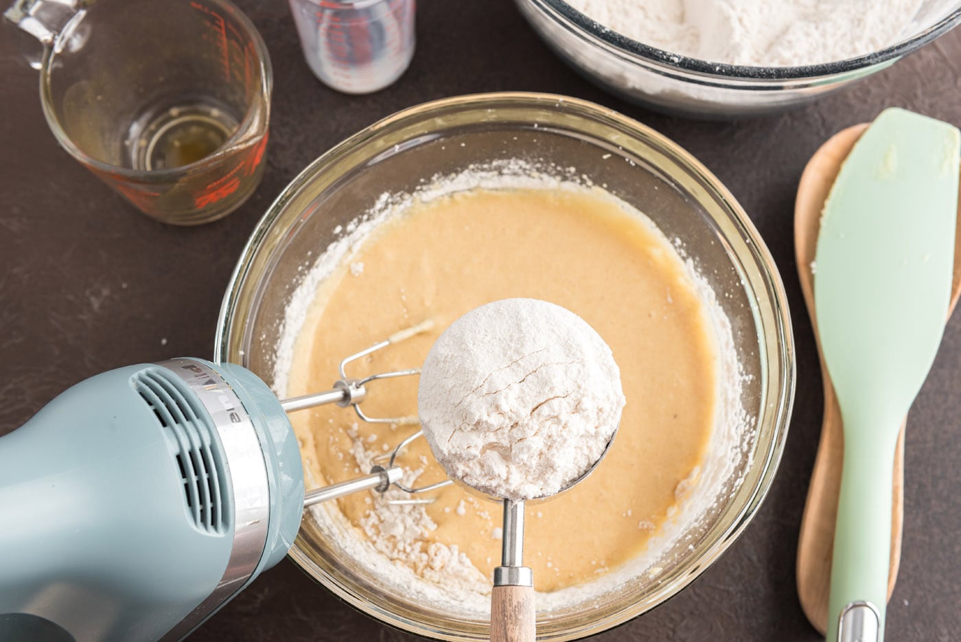 adding flour mixture to wet ingredients in a bowl