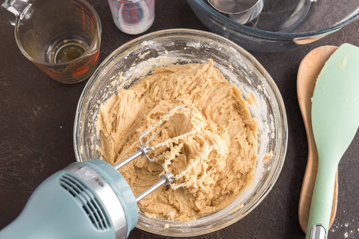 mixing apple cider doughnuts batter with an electric mixer