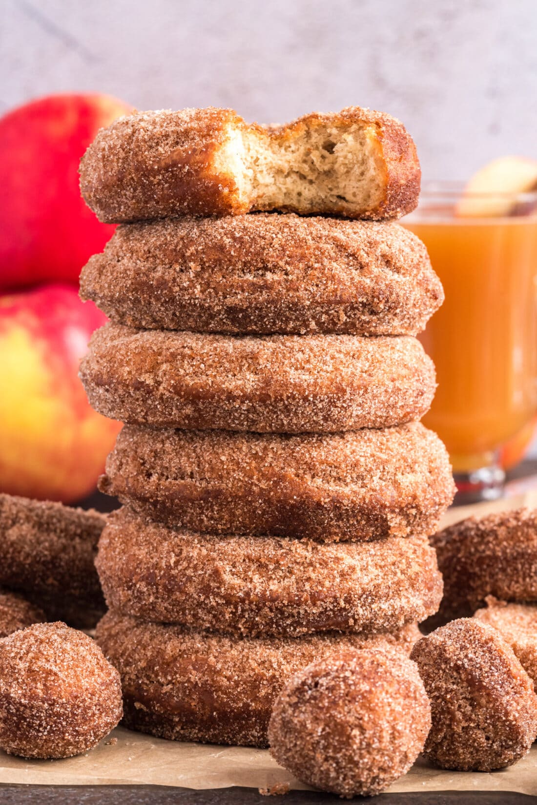Stack of Apple Cider Doughnuts with a bit taken out of the top one