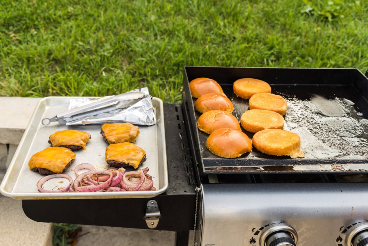 buns, burger patties, and grilled onions on the grill