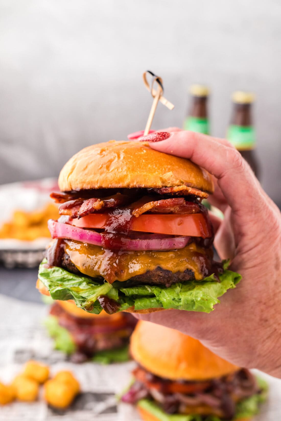 Hand holding up a BBQ Bacon Burger