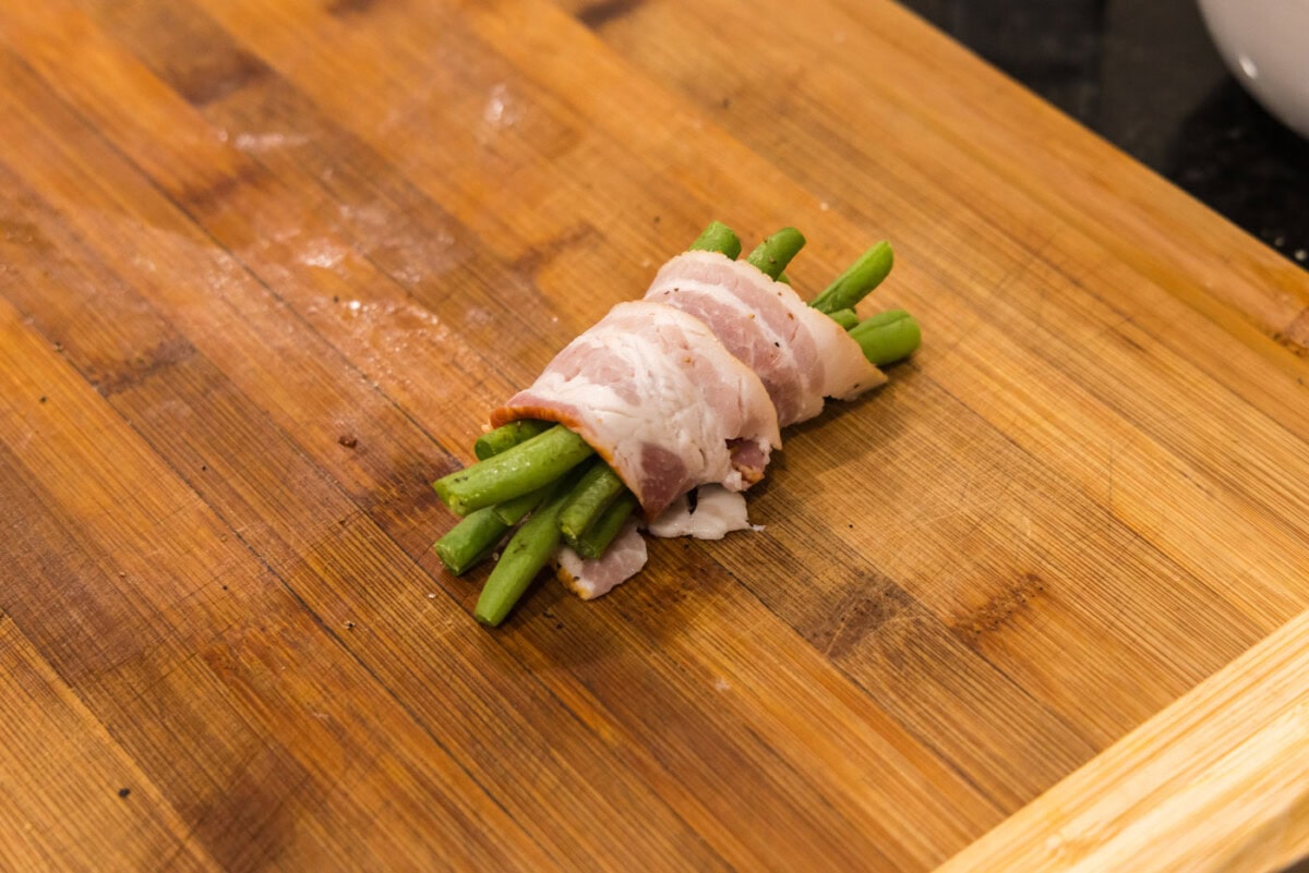 bacon wrapped green beans on a baking sheet