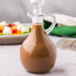 Close up photo of a cruet filled with Balsamic Vinaigrette