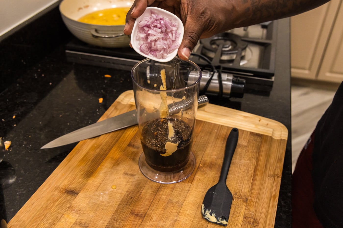 adding shallots to balsamic dressing in an immersion blender