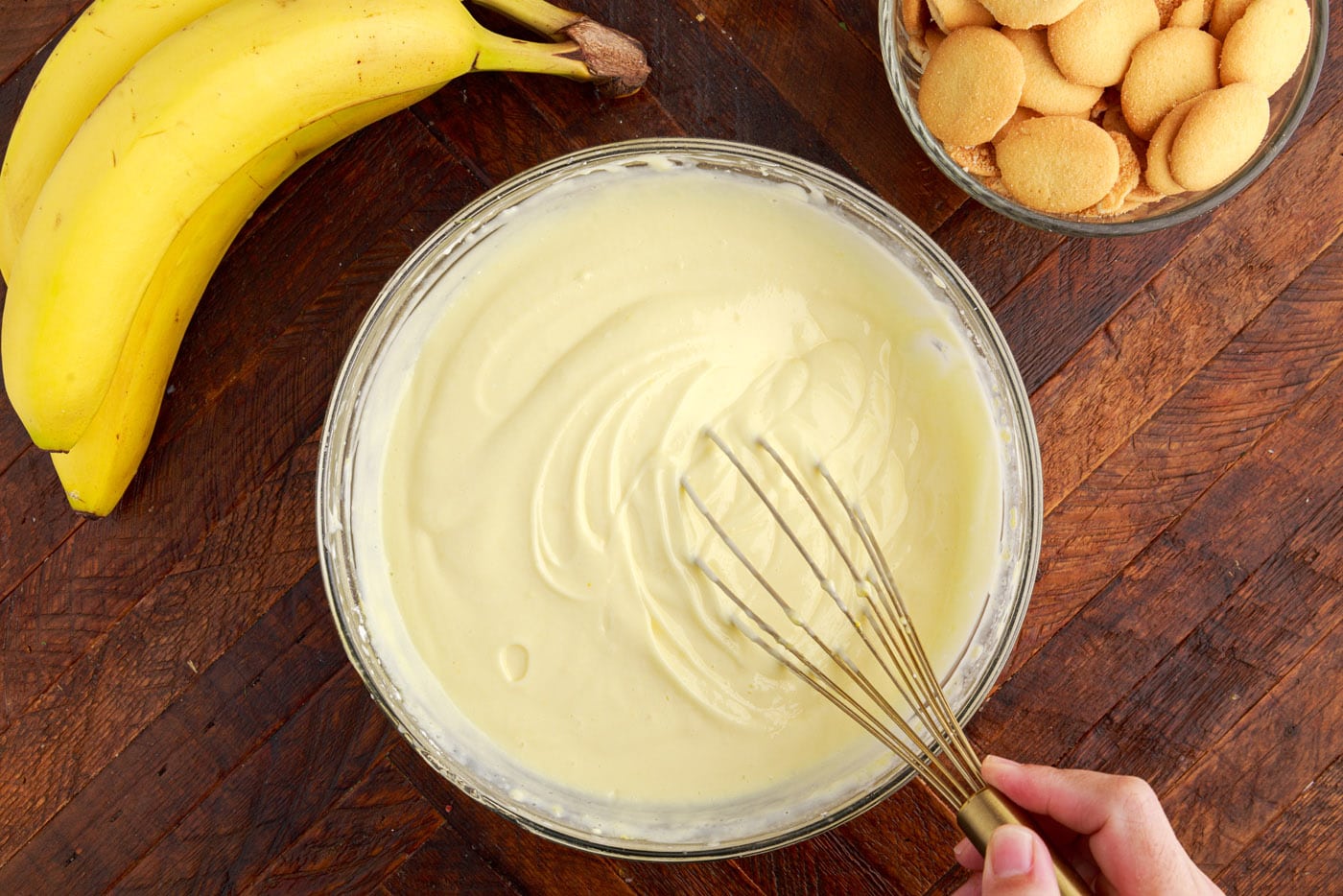 whisking whipped vanilla pudding and cream cheese mixture in a bowl