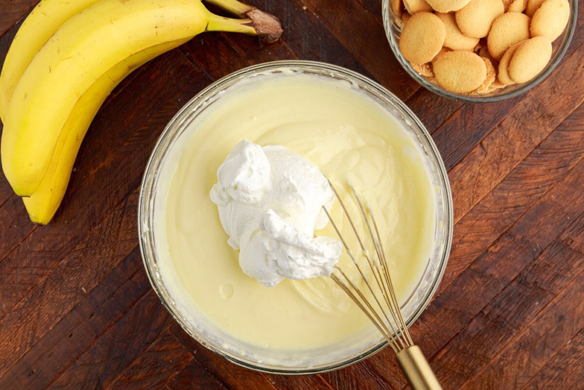 folding a dollop of whipped cream into cream cheese pudding mixture