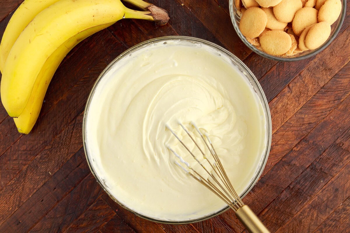 whipped cream cheese vanilla pudding mixture in a bowl with a whisk