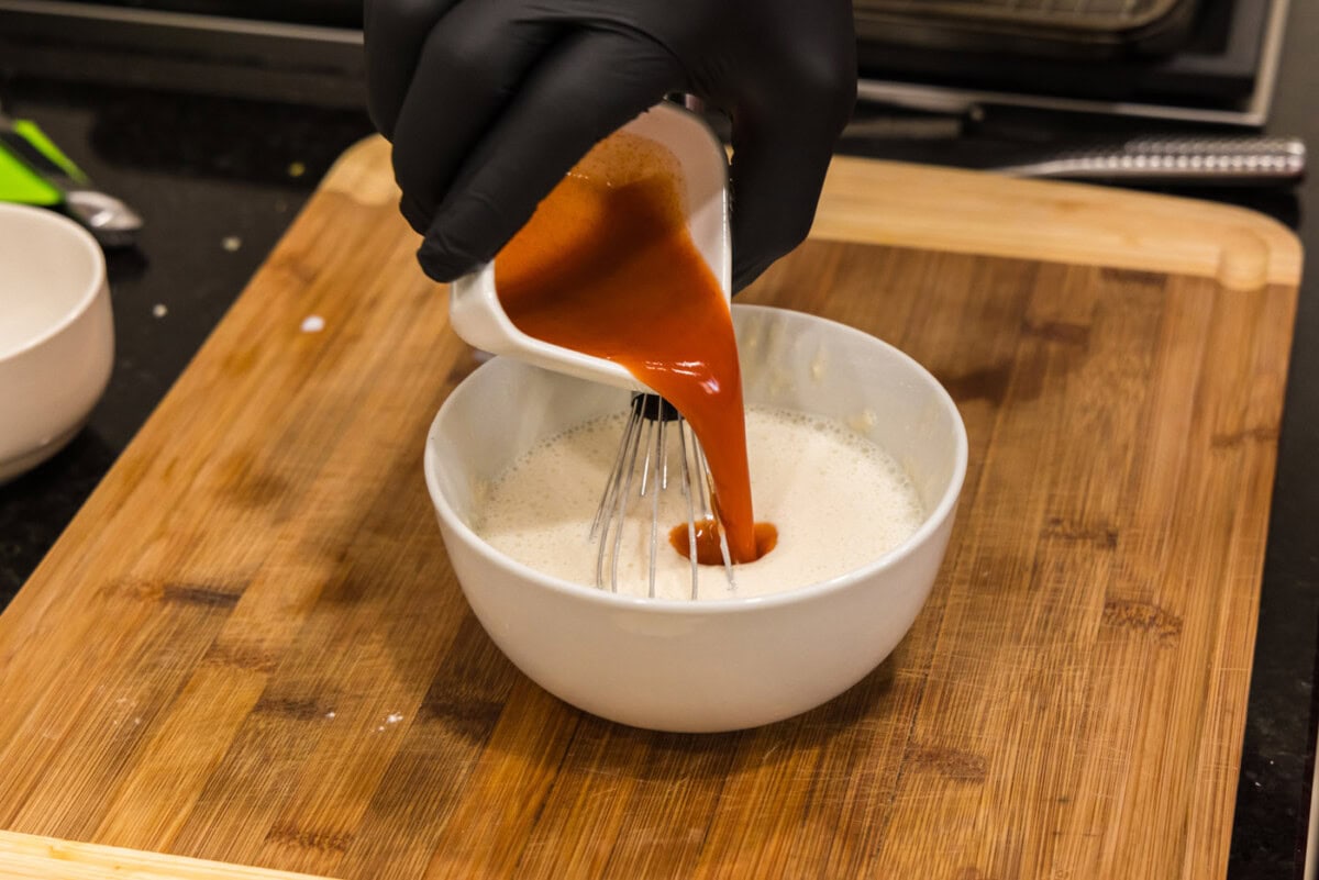adding hot sauce to flour and buttermilk mixture
