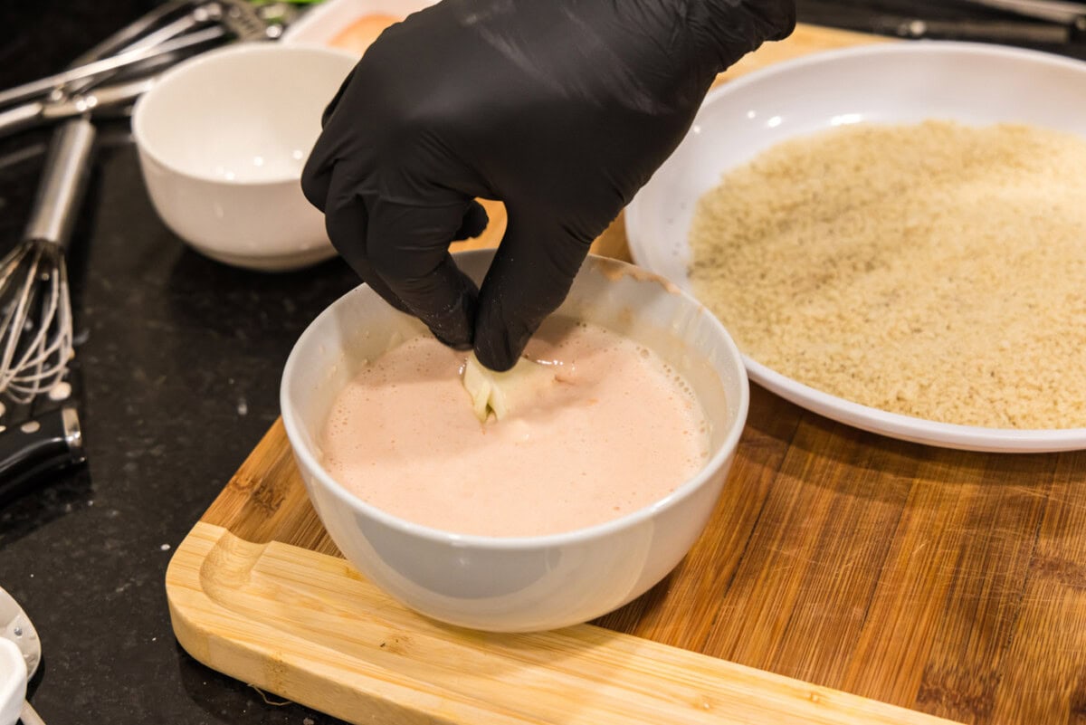 dipping cauliflower into buttermilk mixture