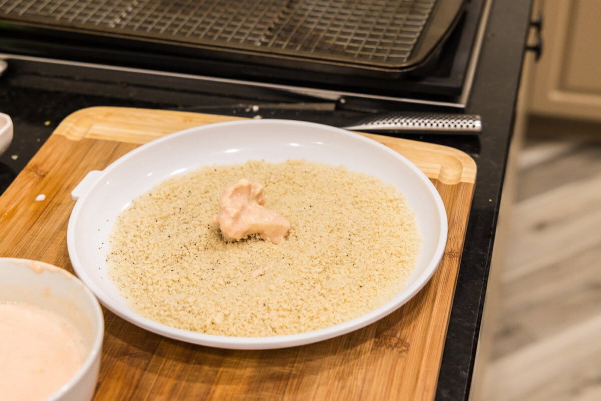 rolling dredged cauliflower in panko bread crumbs