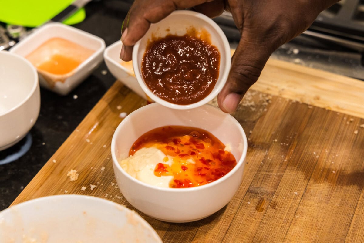 adding asian sweet chili sauce to mayo and sriracha mixture