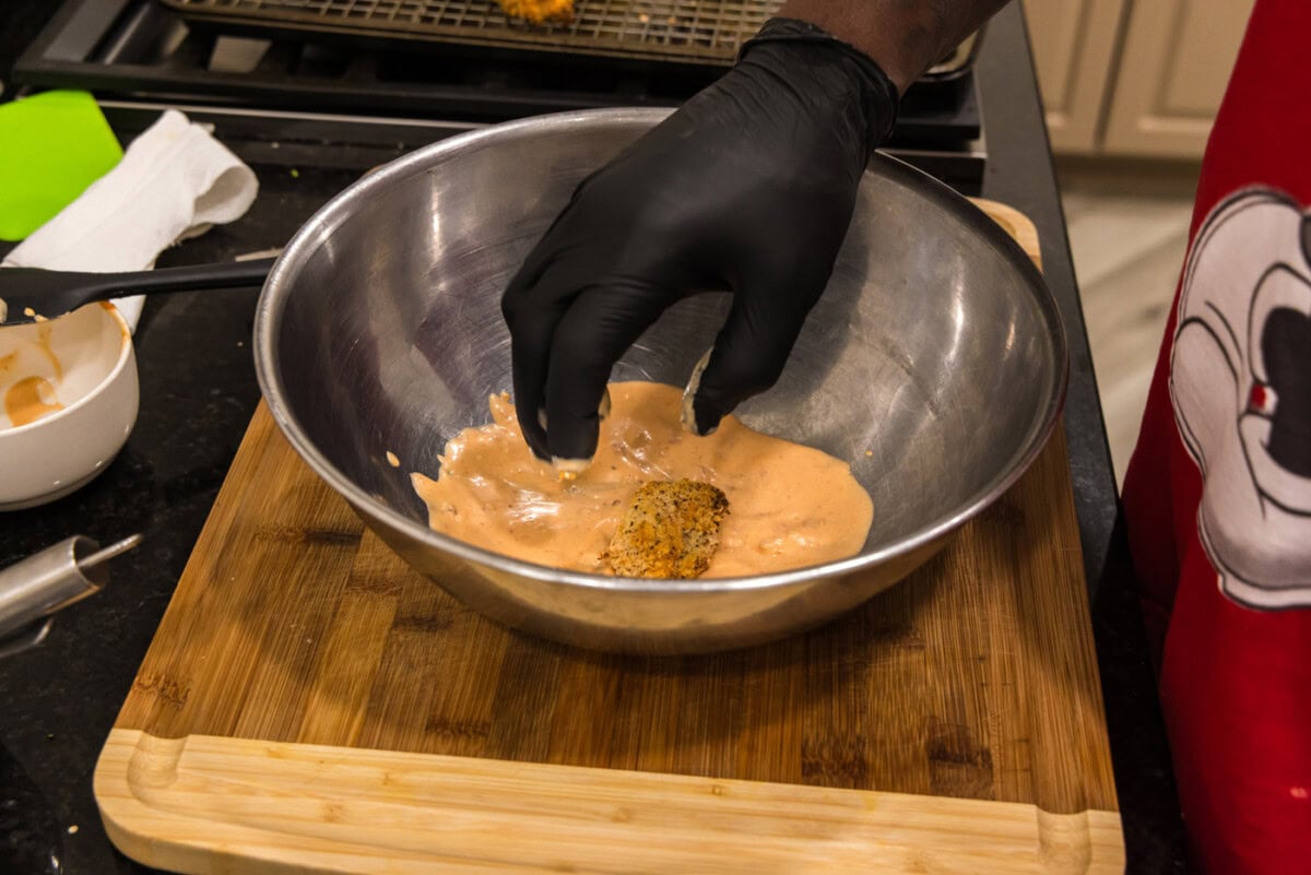 tossing cauliflower florets in bang bang sauce