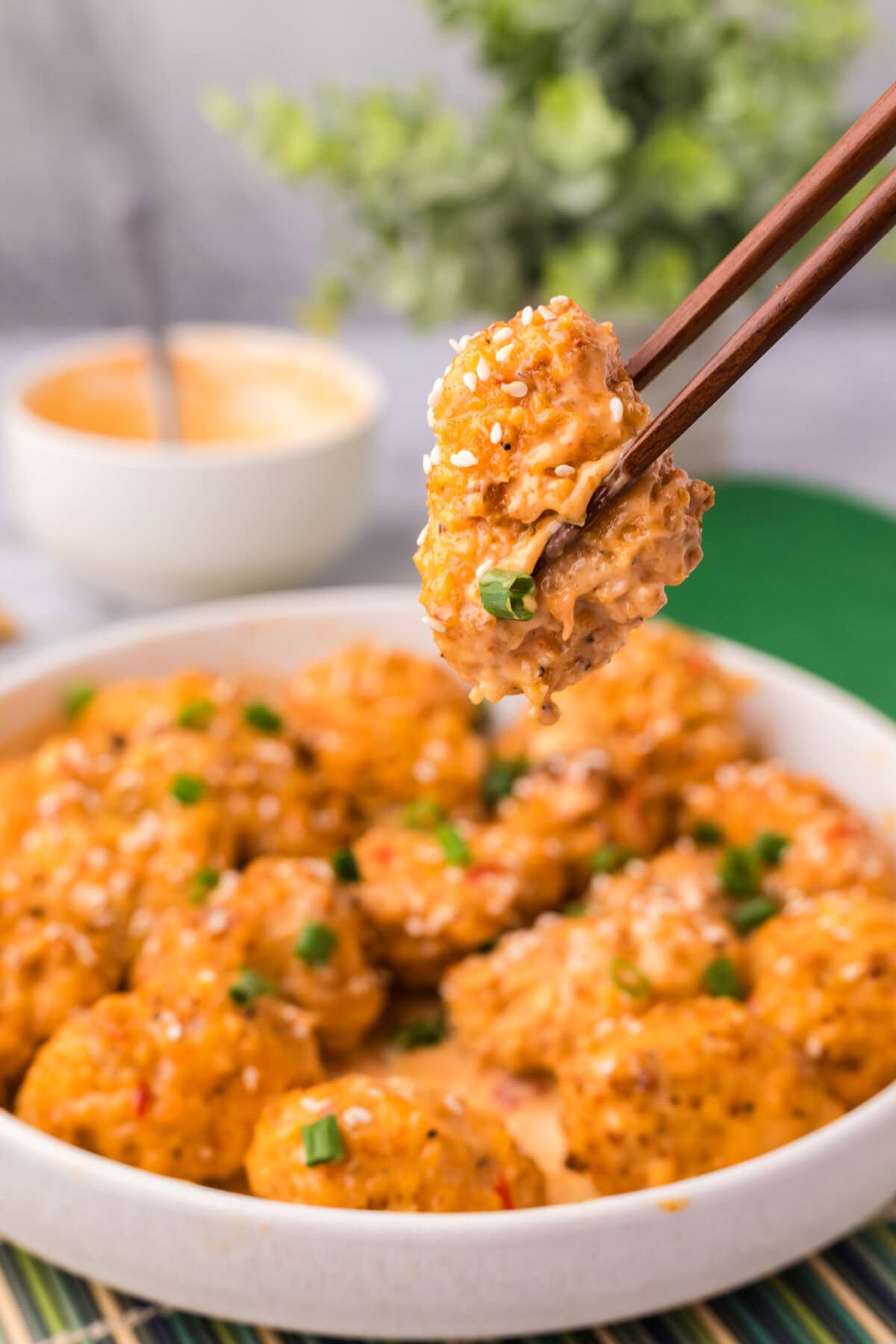 Chopsticks holding a piece of Bang Bang Cauliflower