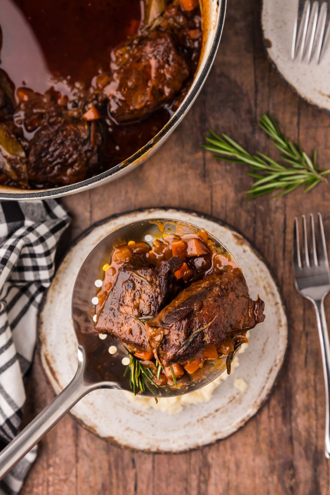 Spoonful of Braised Beef Short Ribs held over a plate