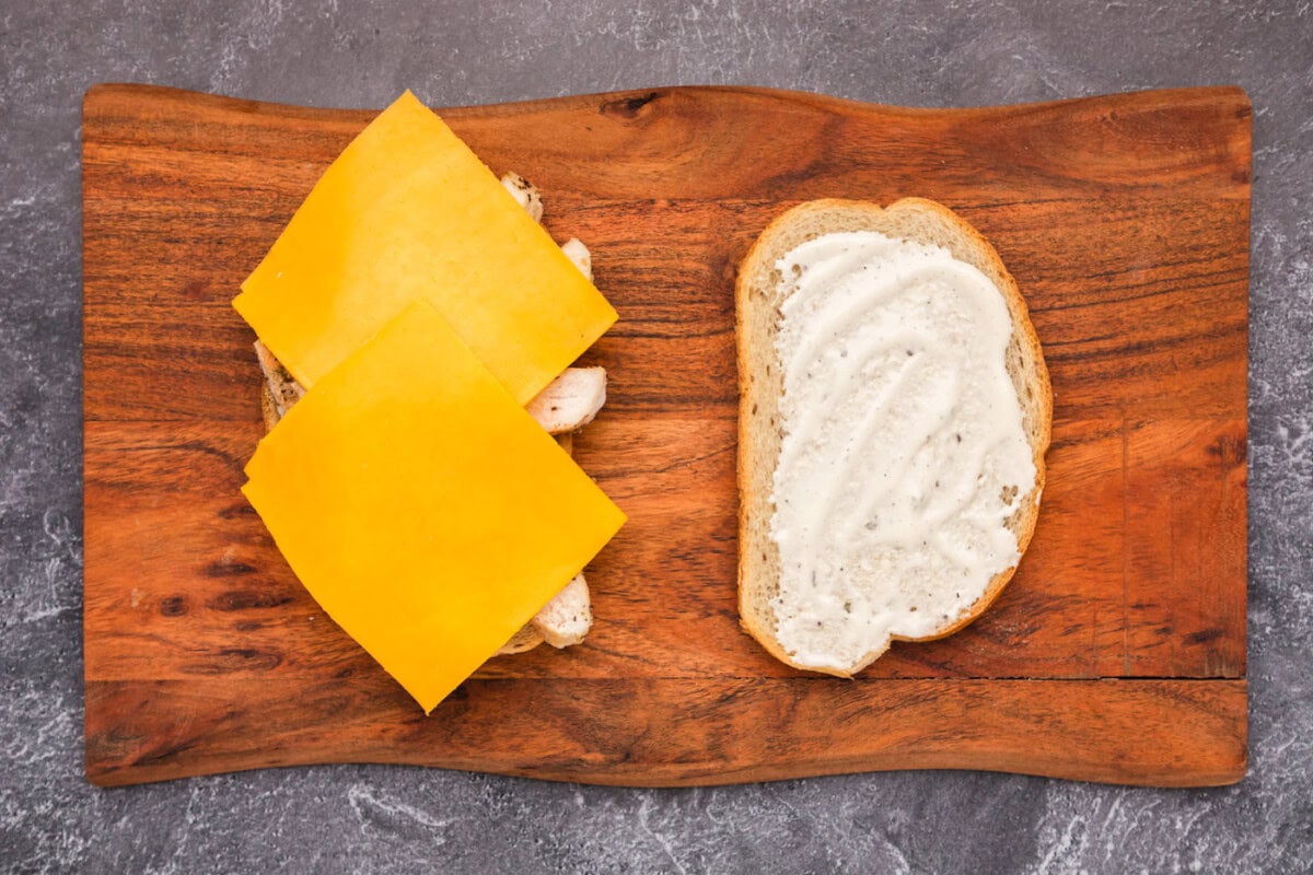 sliced cheese over the top of sliced chicken and ranch dressing