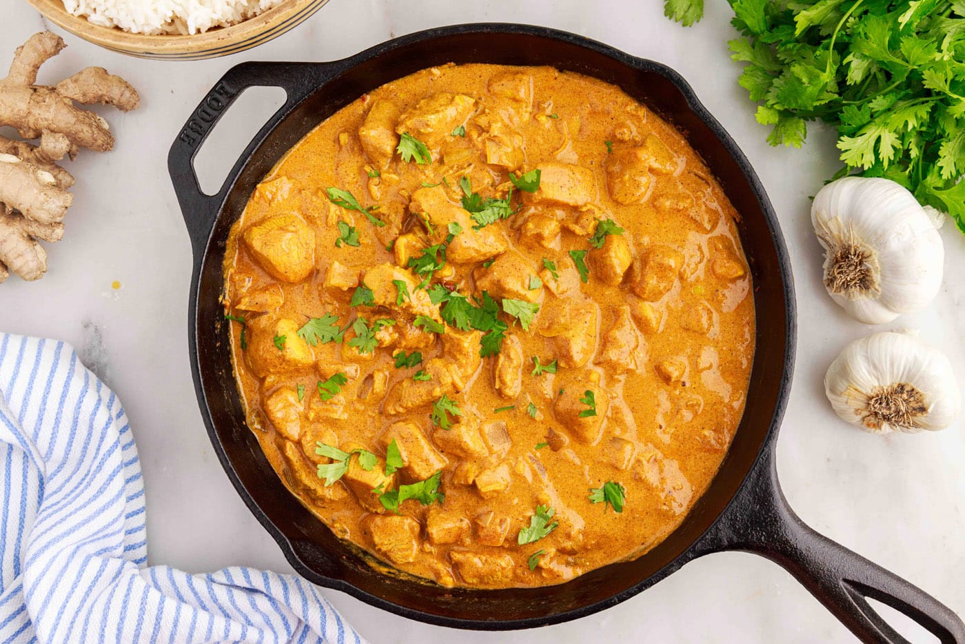 creamy chicken curry in a skillet garnished with chopped cilantro