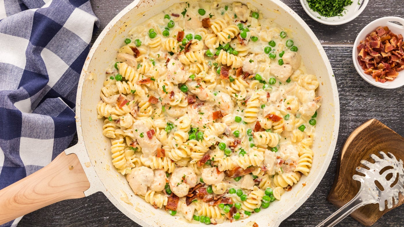 This chicken and shrimp carbonara recipe is rich and satisfying with bacon, peas, garlic, and parmes