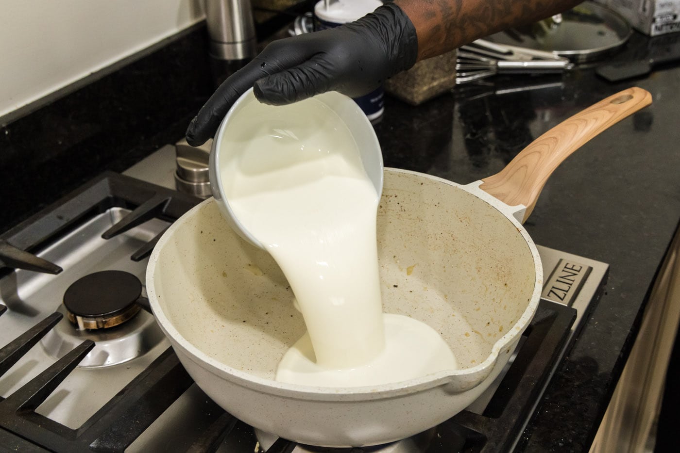 Pouring heavy cream into skillet
