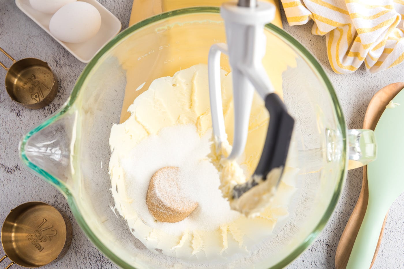 adding sugar to butter mixture in a mixer