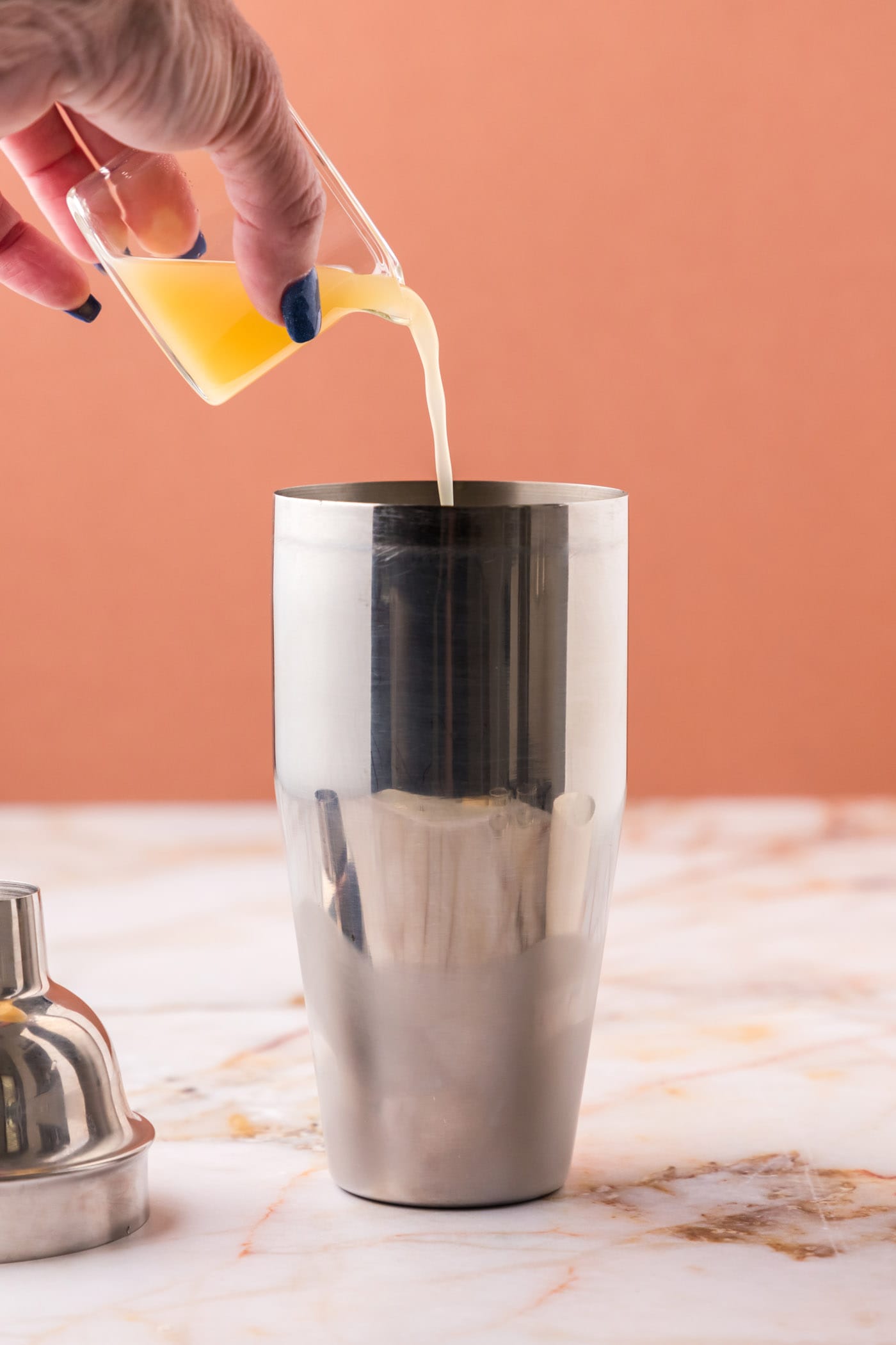 pouring pineapple juice into cocktail shaker