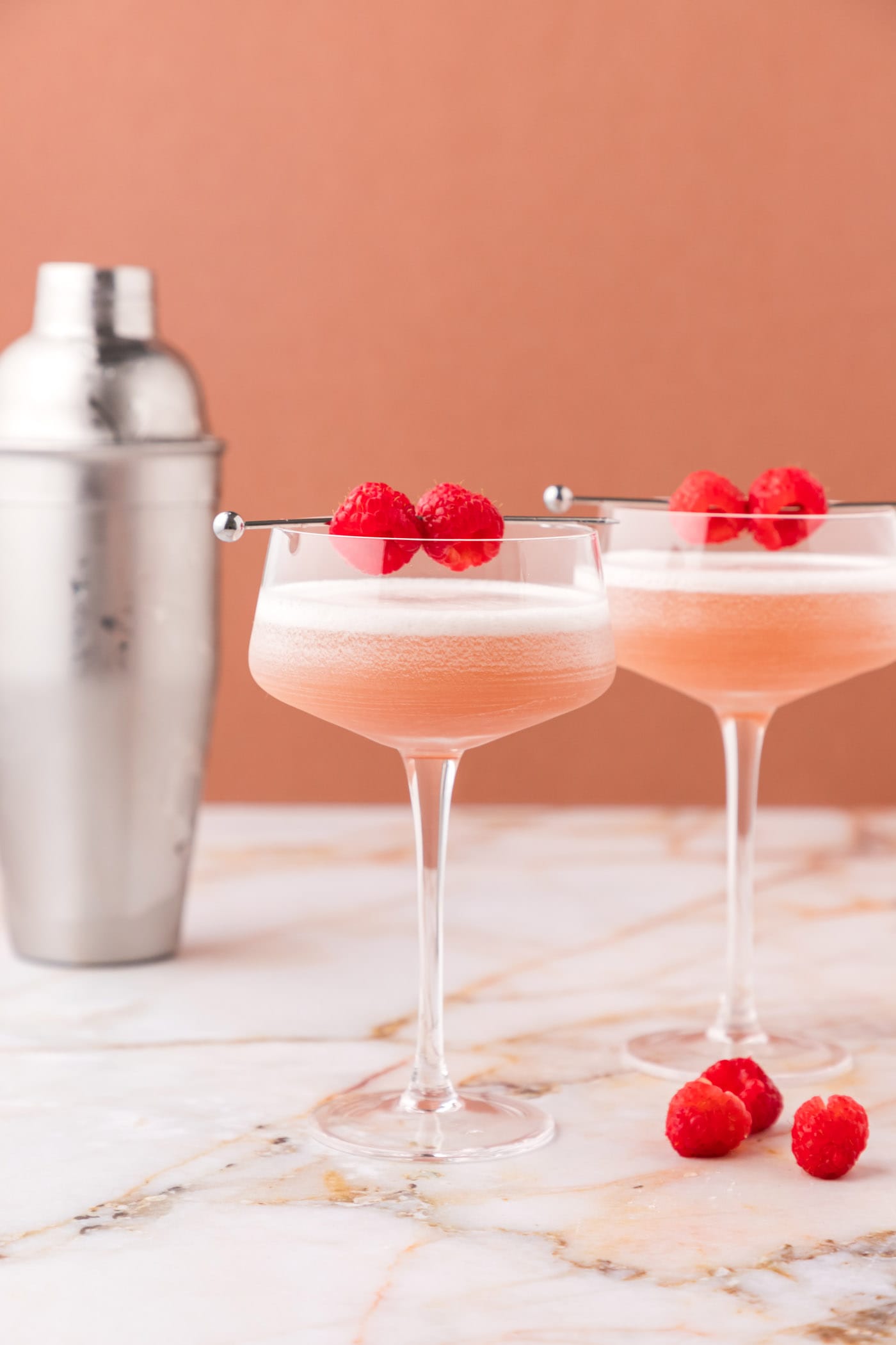 two french martinis with a garnish of fresh raspberries