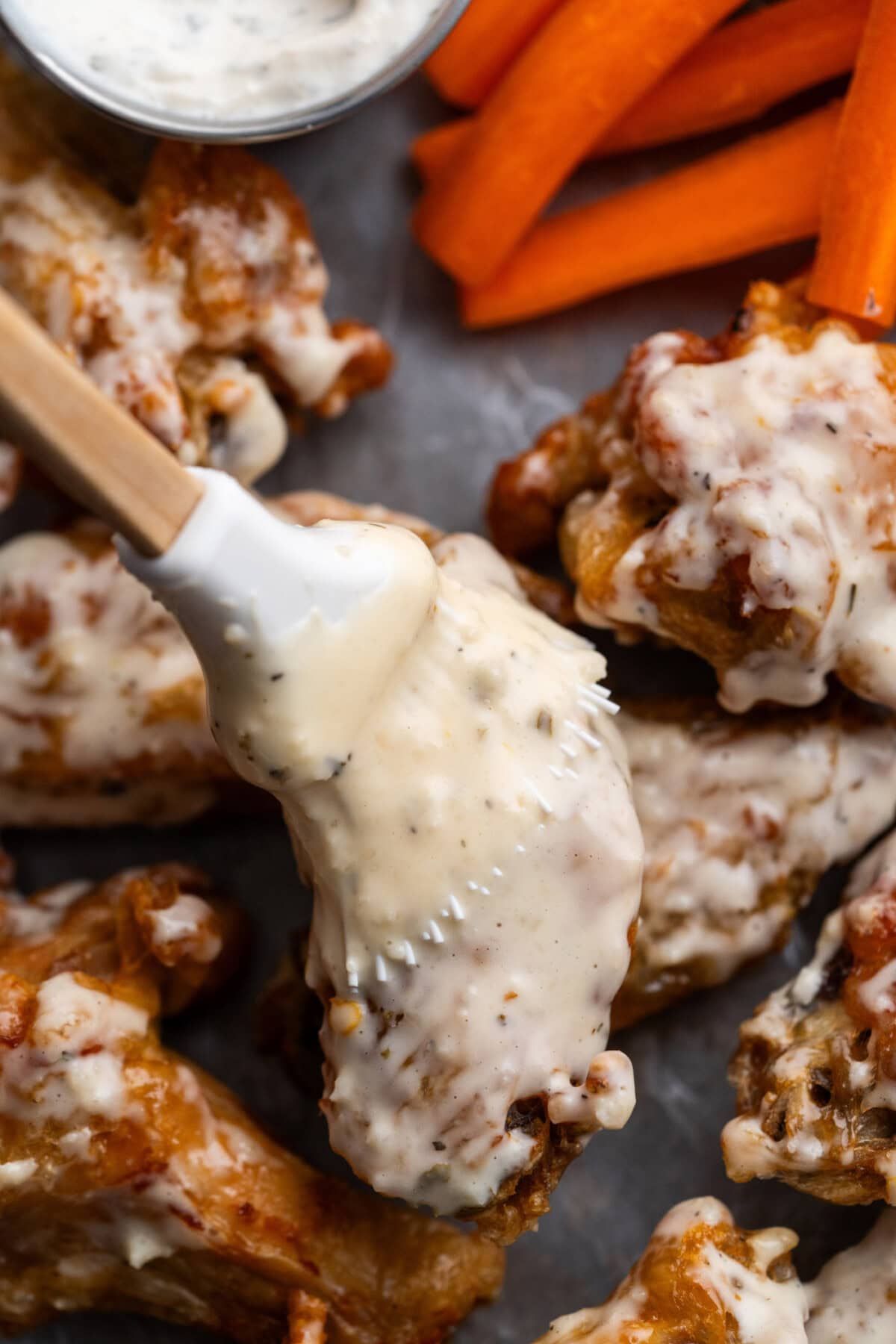 Garlic Parmesan Wing Sauce being brushed on wings