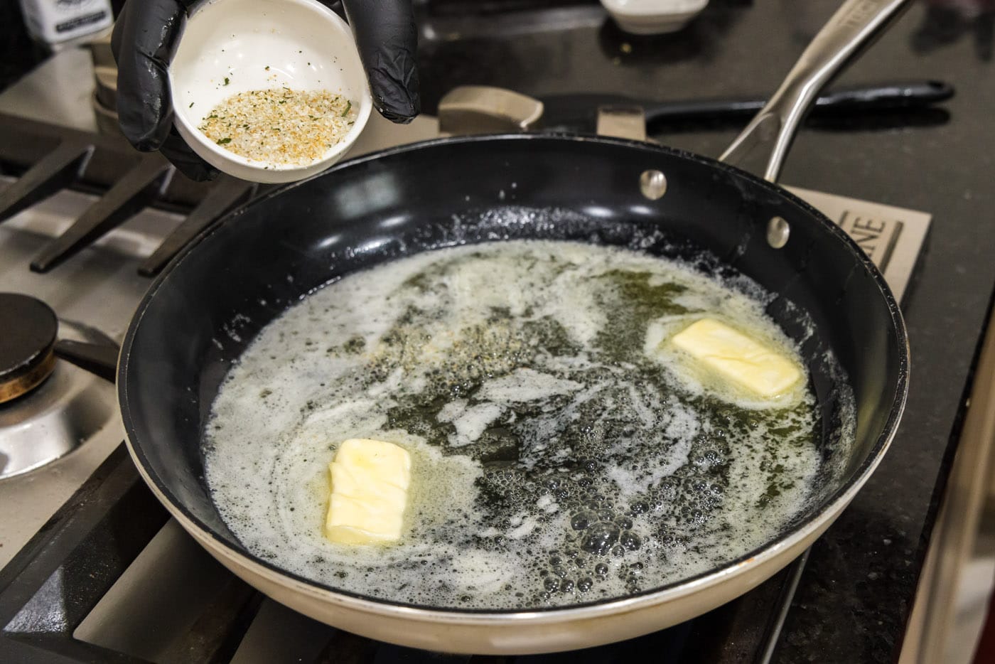 adding seasoning to melted butter in a skillet