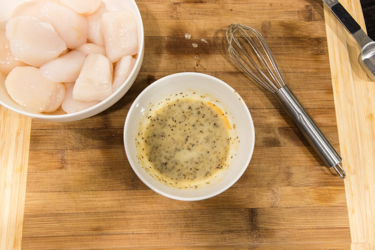 seasoned butter in a bowl next to scallops