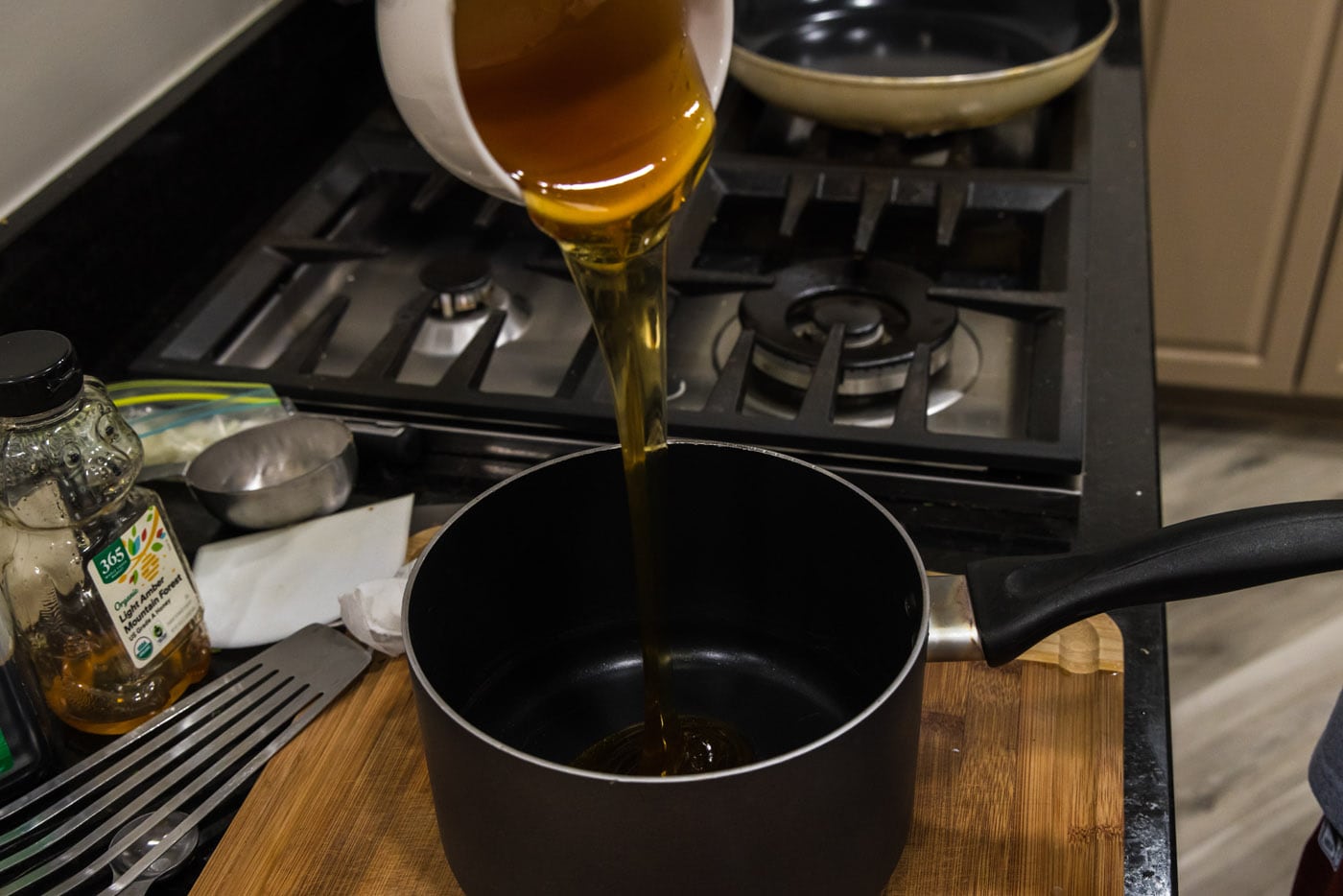 pouring honey into saucepan