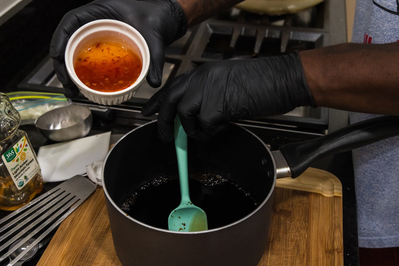 pouring Asian sweet chili sauce into sauce pan