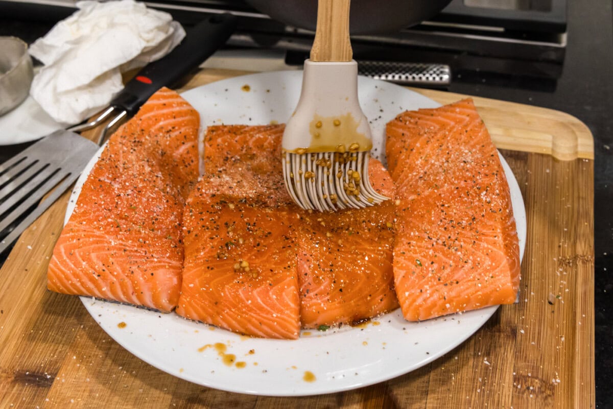 brushing honey garlic glaze over salmon