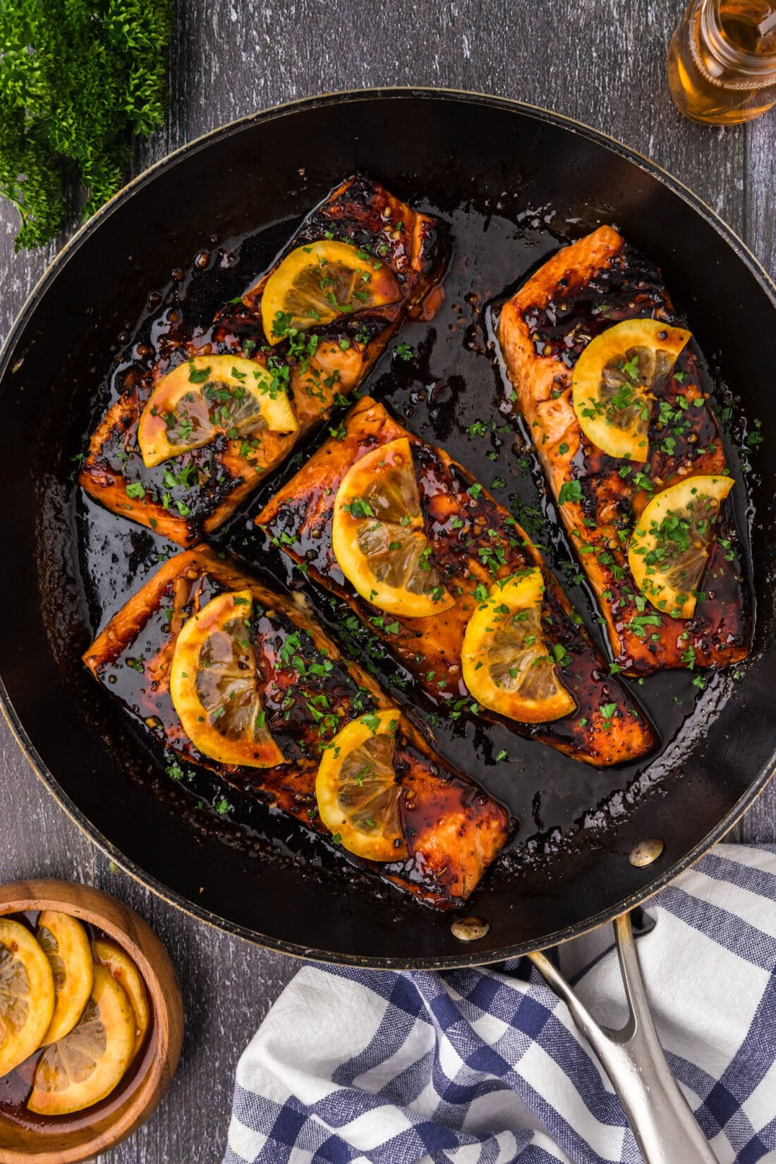 Honey Salmon in a skillet topped with lemon slices