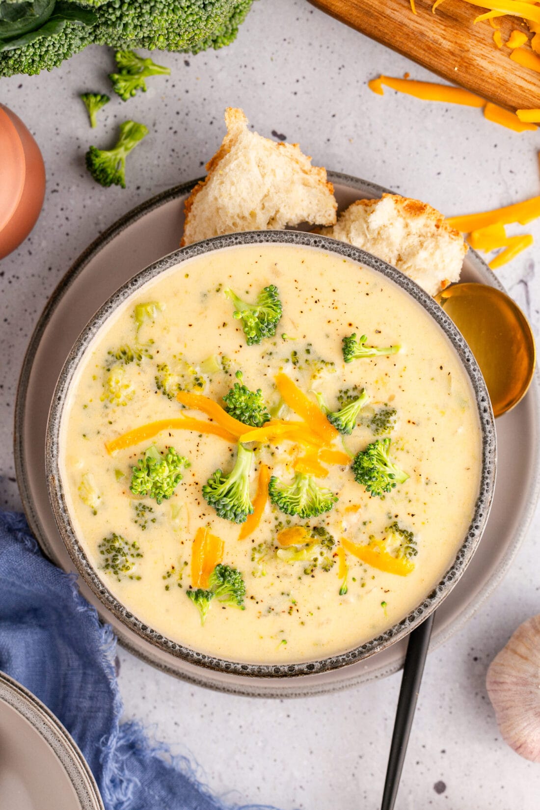 Overhead photo of a bowl of Instant Pot Broccoli Cheddar Soup with bread on the side