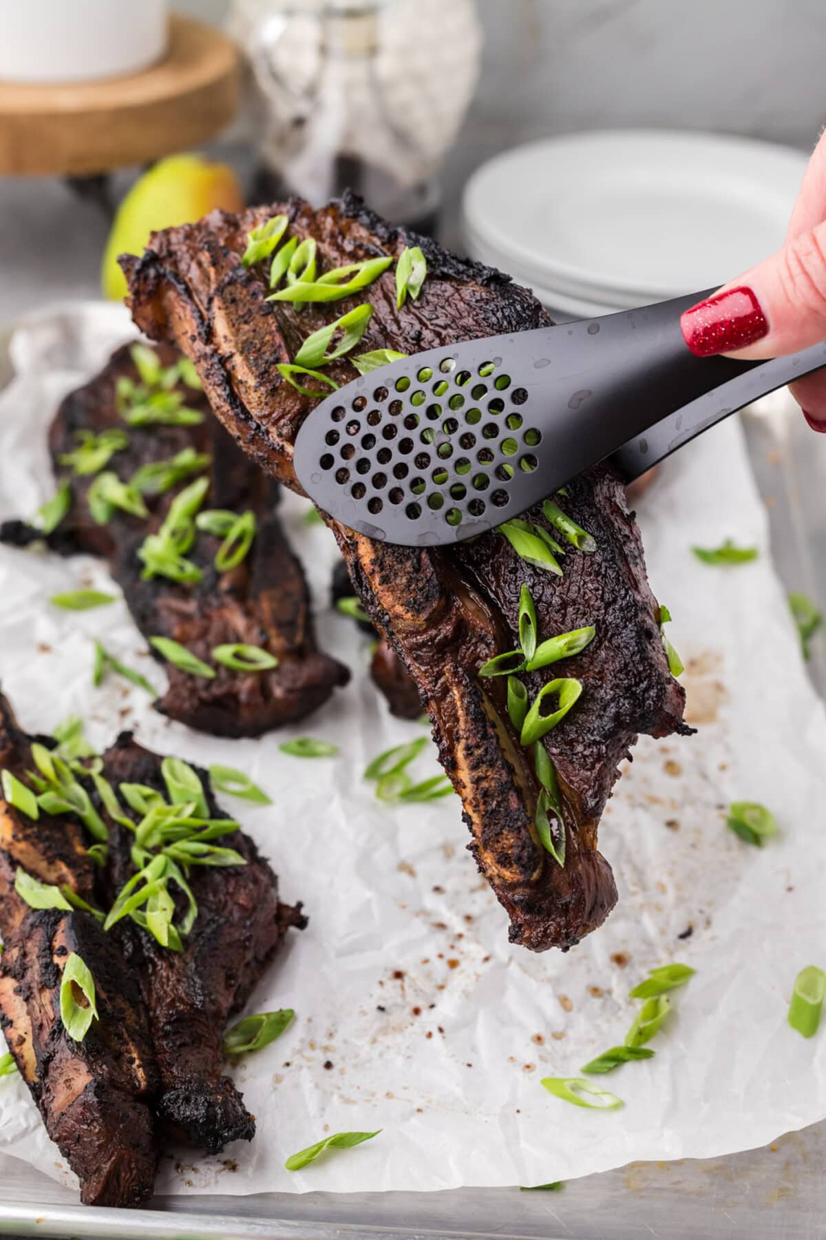Tongs holding up a Korean Short Rib