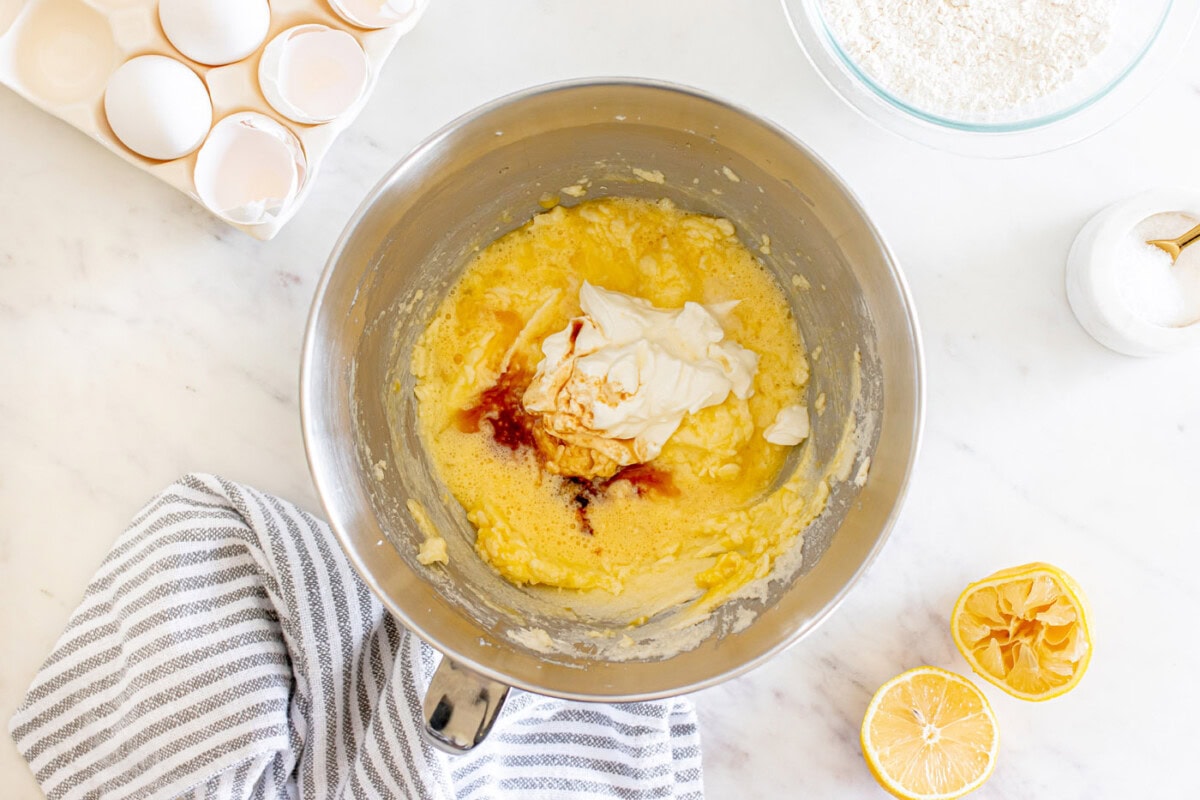 adding sour cream and vanilla to butter mixture in a bowl