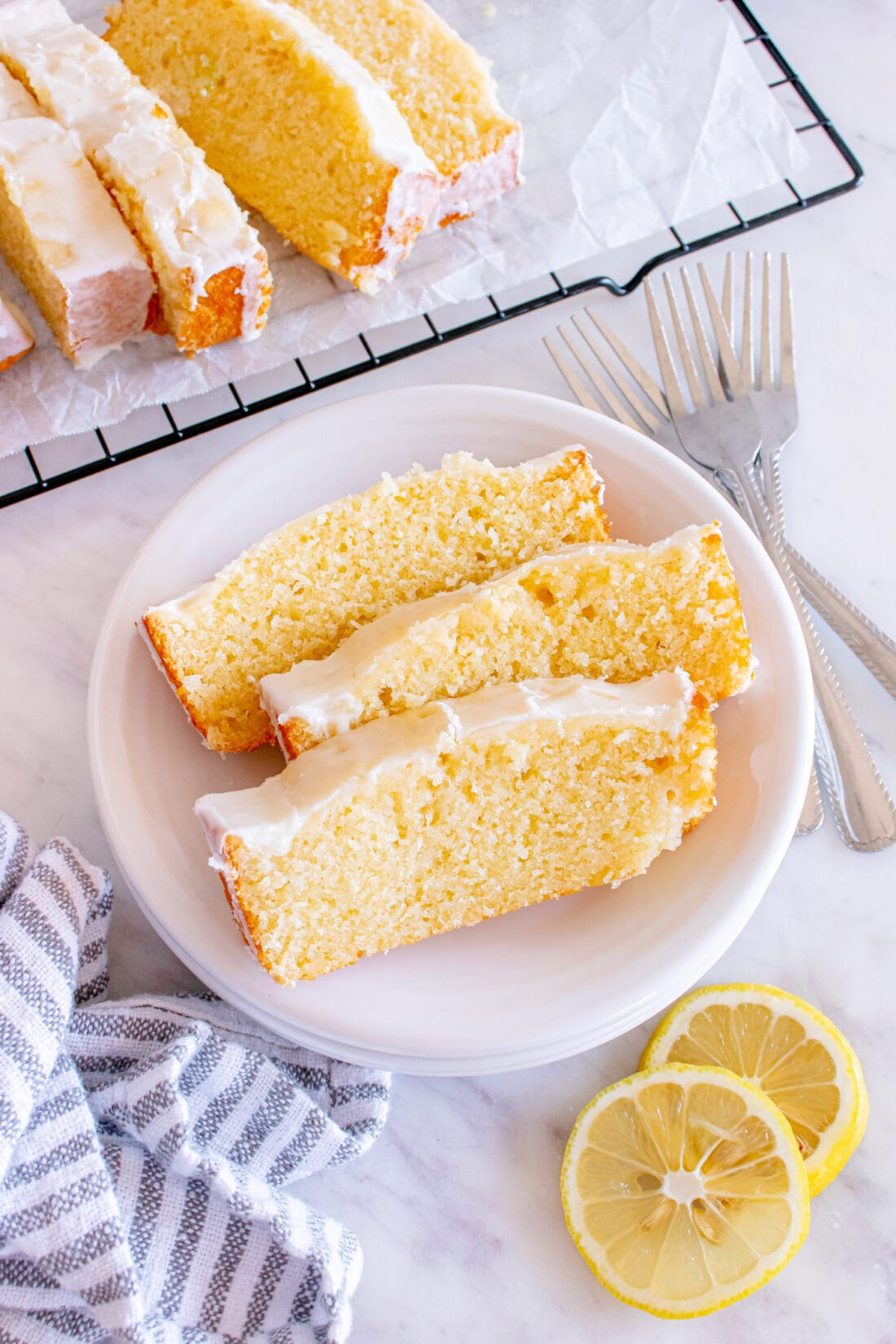 Three slices of Lemon Pound Cake on a plate with more slices in the background