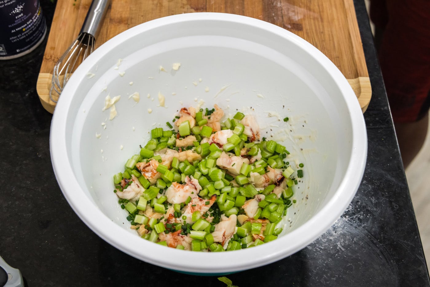 diced celery added to lobster and dressing in a bowl