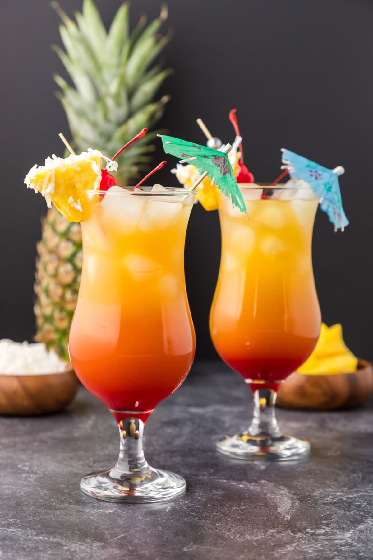 Two Malibu Sunset cocktails with a pineapple in the background