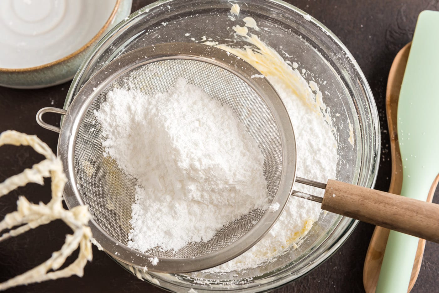 adding sifted powdered sugar to butter mixture