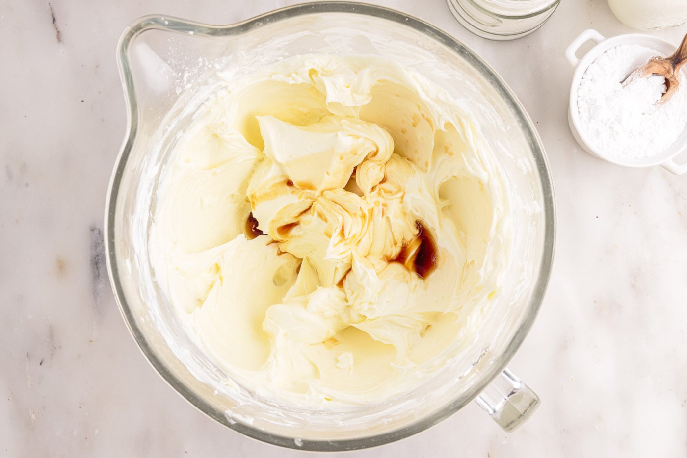 adding vanilla to cream cheese mixture in a bowl