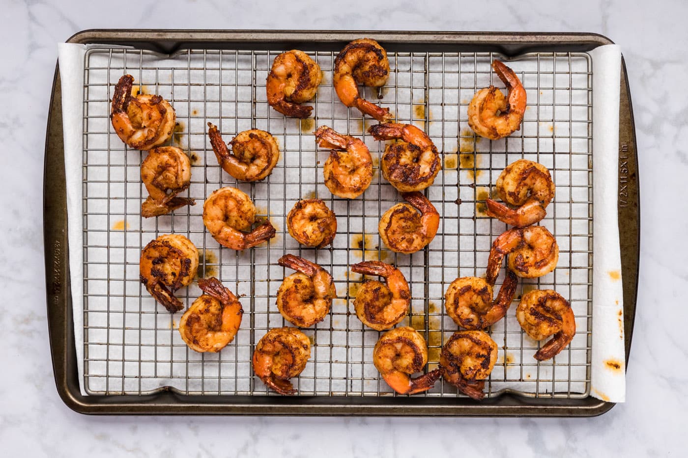cooked spicy shrimp resting on a wire rack
