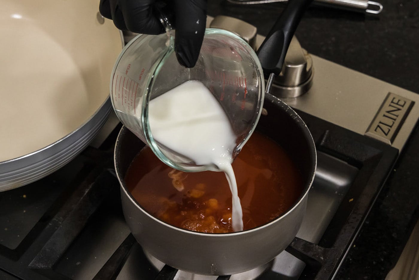 pouring cornstarch slurry into sweet and sour sauce