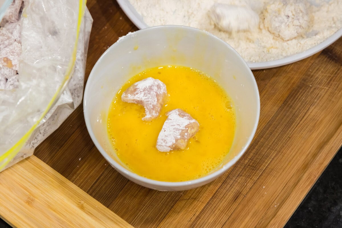dipping cornstarch coated chicken in whisked eggs