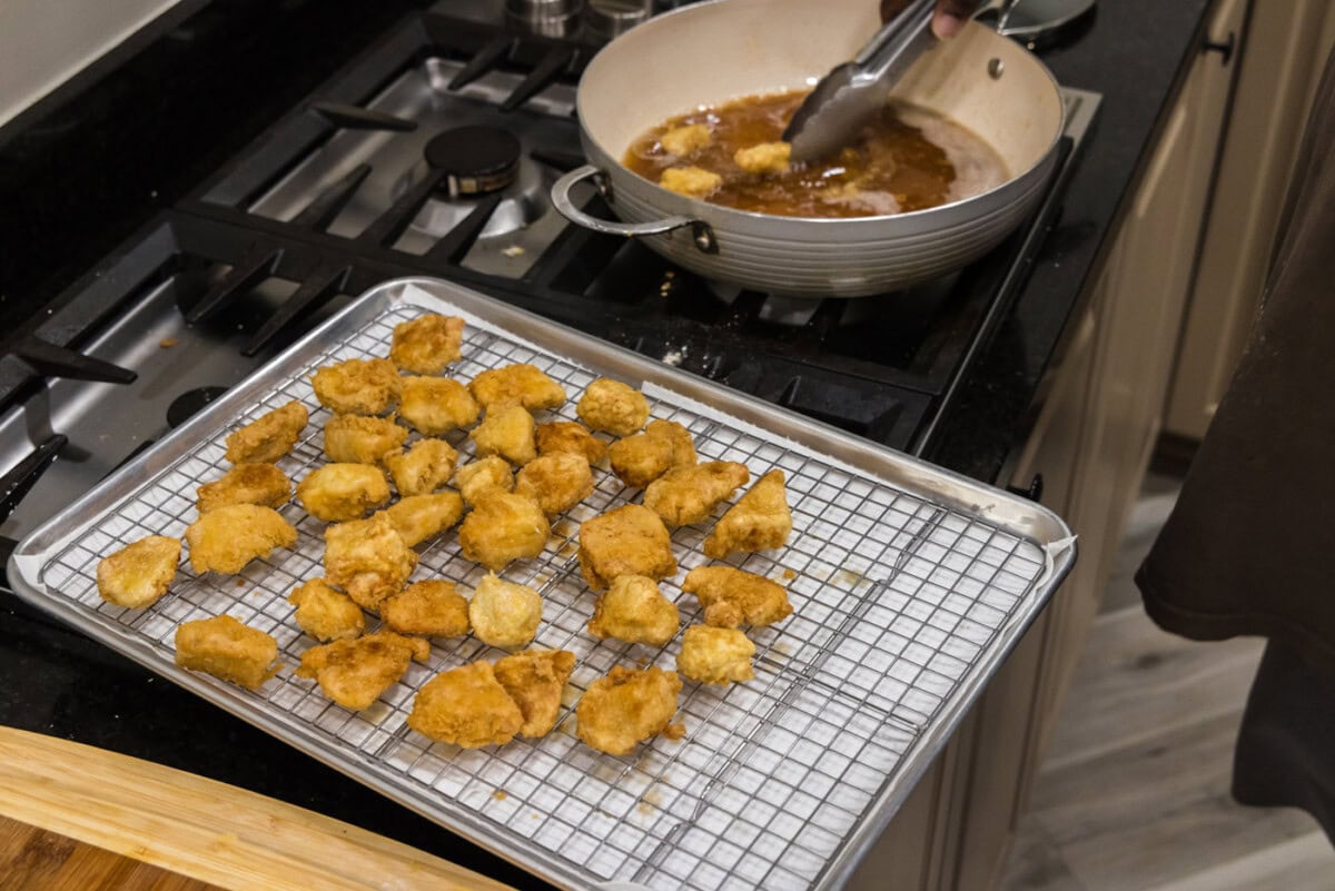 fried chicken cubes draining on a wire rack